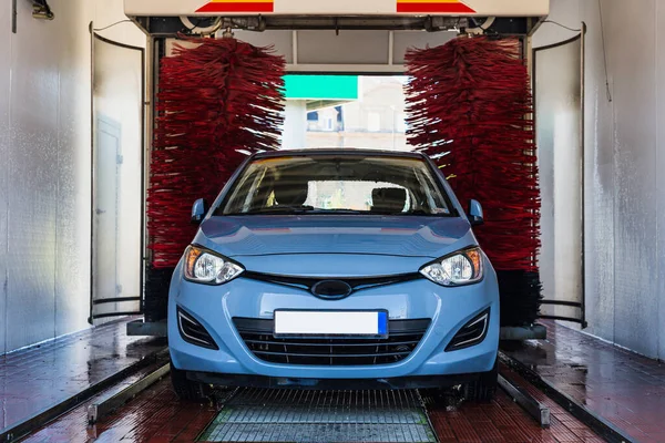 Car washing machine. Auto brush washer clean blue car on automatic carwash station. Automated car washing machine background
