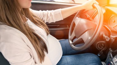 Pregnant woman driver. Beautiful smiling pregnancy woman driving car. Safety pregnant young mother drive concept
