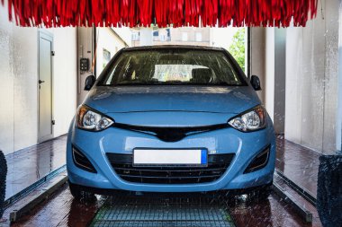 Car wash background automatic carwash. Brush washer clean blue auto car on automatic carwash station. Automated car washing service