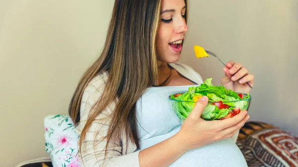 Pregnancy eating healthy salad. Happy pregnant woman eating nutrition food. People lifestyle food concept