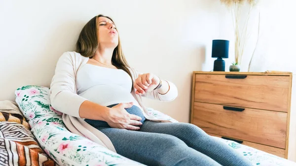 怀孕时间分娩 分娩时间 宫缩疼痛 怀孕妇女看钟表 抱着小肚子 药物保健概念 — 图库照片