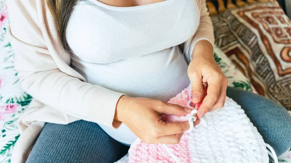 靴下を編む妊娠中の女性 妊娠中の母親のかぎ針編みの子供の布 かわいい妊娠女性ニットファッション冬の赤ちゃんの女の子の服 居心地の良い編み物女性 — ストック写真