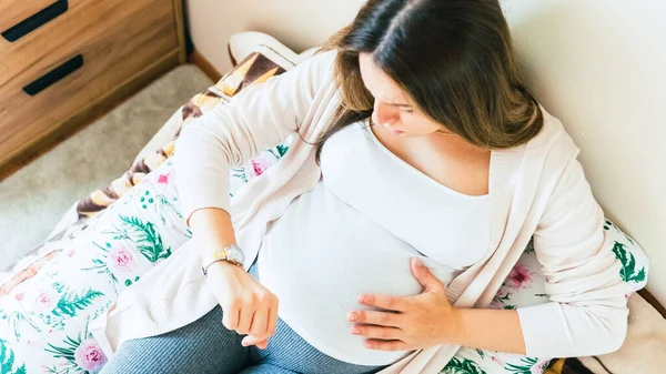 妊娠時計出産 出産時間 収縮の痛み 妊娠中の女性は 赤ちゃんの腹を保持時計 医学ヘルスケアの概念 — ストック写真