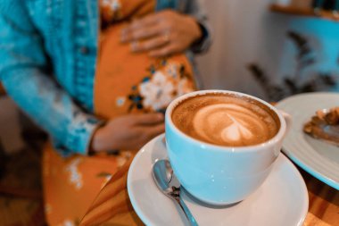 Pregnant woman coffee drink. Lifestyle morning with happy pregnancy girl drink espresso coffee. Represent breakfast, energy, freshness or great aroma concept