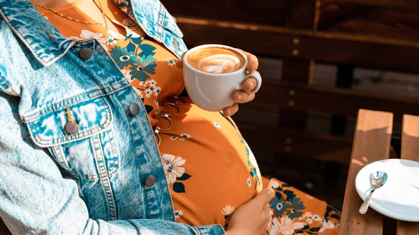 Pregnant woman drink coffee. Lifestyle morning with happy pregnancy girl drink espresso coffee. Concept for coffee product advertising