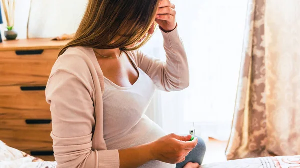 Pregnant sick fever thermometer. Pregnancy woman holding thermometer, check fever flu temperature. Pregnant girl sick. Pregnancy, medicine health care concept