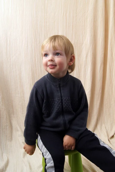 Niño se sienta y muestra la lengua —  Fotos de Stock