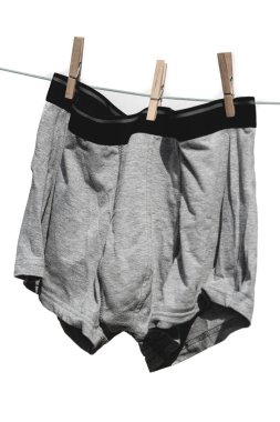 Erkekler külotları beyaz arka planda izole edilmiş bir iple kurutulur..