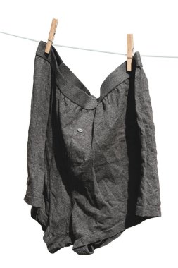 Erkekler külotları beyaz arka planda izole edilmiş bir iple kurutulur..