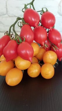 Fresh red and yellow cherry tomatoes on blue plate.