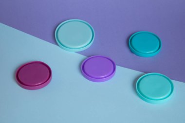 Kağıt arka planda mavi ve mor plastik kapaklar. Üst görünüm