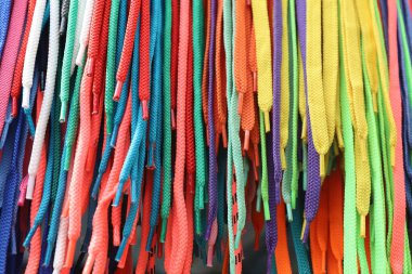 Soyut model. Çok renkli parlak ayakkabı bağcıkları dikey sırada sıkıca dizilir. Ön görünüm