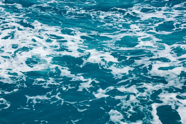 Surface de l'eau. Réveillez les vagues et la mousse sur l'eau de mer bleue — Photo
