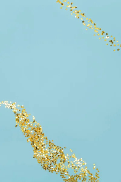 Csillag alakú arany konfetti világoskék háttér — Stock Fotó