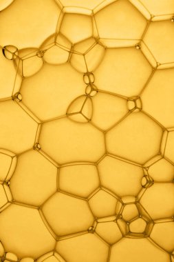 Baloncukların yüzeyi. Sarı, altın arkaplanda sabun köpüğü yapısına aşırı yakın çekim