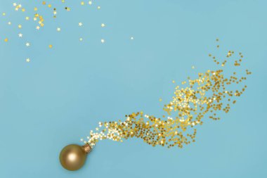 Matte Golden Christmas balosu ve parlak mavi arka planda yıldız şeklinde konfeti. Parlak pullar. Uzayı kopyala Düz yatıyordu