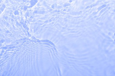 Odaklanmamış bulanık mavi renkli berrak sakin su yüzeyi dokusu sıçrama ve kabarcıklarla. Moda soyut doğa geçmişi. Güneş ışığı altında su dalgaları kopyalama alanı ile.
