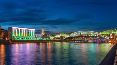 Moskova Nehri 'ni yansıtan renkli Bogdan Khmelnitsky köprüsünün görüntüsü. Moskova Kiyevsky tren istasyonu, gece. Moskva Nehri üzerindeki yaya köprüsü. Moskova, Rusya