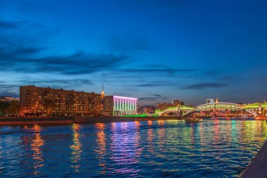 Moskova Nehri 'ni yansıtan renkli Bogdan Khmelnitsky köprüsünün görüntüsü. Moskova Kiyevsky tren istasyonu, gece. Moskva Nehri üzerindeki yaya köprüsü. Moskova, Rusya