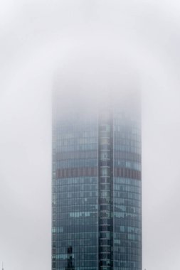 Modern gökdelen sisin içinde gizlidir. Sisin içinde saklanıyor.