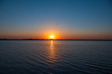 Güneş bir gölün üzerinde batar. Dramatik Günbatımı Gökyüzü