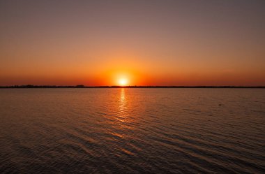 Güneş bir gölün üzerinde batar. Dramatik Günbatımı Gökyüzü