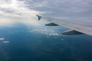 Güzel mavi bir güneş doğarken uçak penceresinden ve açık havada uçağın kanadını seyret. Dünya ve gökyüzü bir uçağın penceresinden görüldüğü gibi.