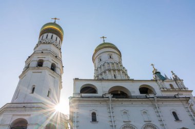 Büyük çan kulesi İvan, sağda mavi gökyüzü olan güneşli bir günde çan kulesi var. Güneş ışınlarıyla mavi gökyüzü arkaplanı. Moskova Kremlin, Rusya