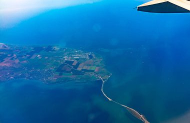 Güzel mavi gökyüzü, toprak, deniz ve uçak kanadına uçak penceresinden bakın. Dünya, deniz ve gökyüzü bir uçağın penceresinden görüldüğü gibi.