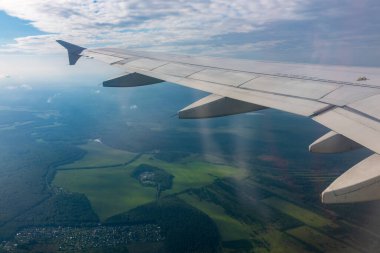 Güzel mavi bir güneş doğarken uçak penceresinden ve açık havada uçağın kanadını seyret. Dünya ve gökyüzü bir uçağın penceresinden görüldüğü gibi.