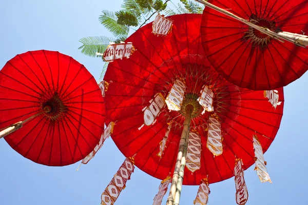 Röda paraplyer på himmel bakgrund — Stockfoto
