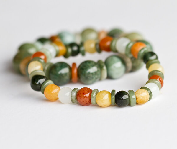 Цветные нефритовые браслеты на белом фоне
