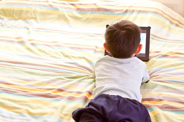 Çinli çocuğun yatakta yatıyordu süre tablet kullanma