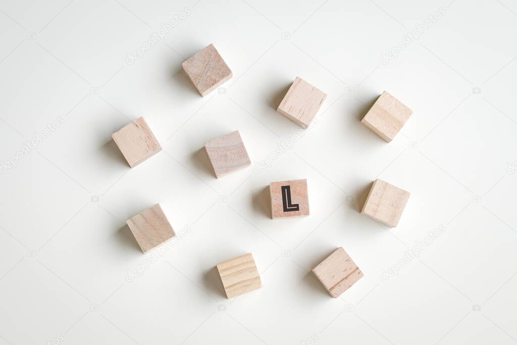 Wood cubes on white background with one L letter on one of the cubes. Leadership concept.