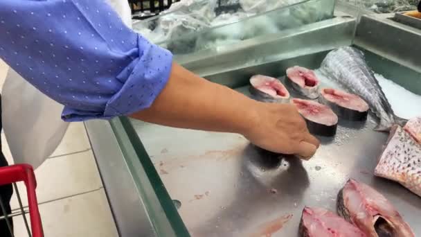 切断された魚を選択し スーパーマーケットでビニール袋の中に入れて男のショットを閉じます 食料品のショッピングコンセプト — ストック動画