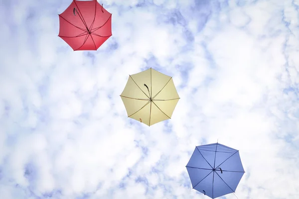 雲と青空に3つの傘 黄色と青の色 スペースのコピー — ストック写真
