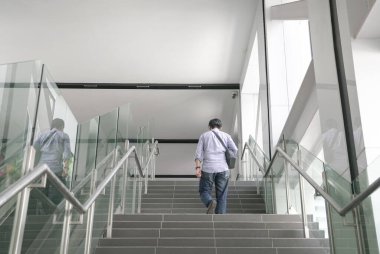 Bir metro binasının içinde merdivenlerden çıkan adamın arka görüntüsü. İş konseptine seyahat.