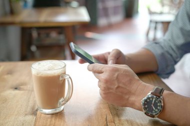 Mesajlaşmak ya da internette sörf yapmak için telefonu kullanan bir adam. Görüntüyü kapat.