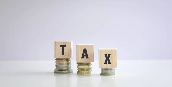 積層コインの上に 木製の立方体上の単語税 税務申告の概念 — ストック写真