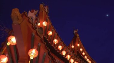 Tapınağın çatısına kırmızı fenerler asmak. Düşük açı görünümü.