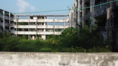 Terk edilmiş ve terk edilmiş bir daire ya da ofis binası. İHA tepsisi yerleşkenin içinde ağaçların ve bitkilerin görüntüsüyle vuruldu..
