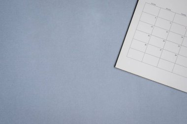 Mavi gri arka planda beyaz temiz takvim. Proje çizelgesi, seyahat planlaması veya anımsatma kavramı.