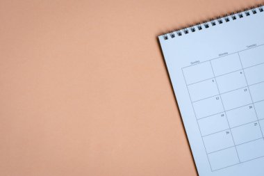 Bej arkaplanda fotokopi alanı olan beyaz temiz takvim. İş toplantısı, seyahat planı veya hatırlatma kavramı.