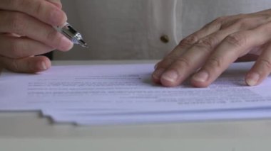 İş kadınının ofis masasının üstünde kontrat imzalarken yakın plan görüntüsü.
