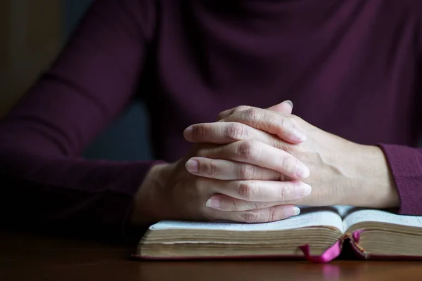 stock image Woman hands in prayer posture on top of open bible. Copy space.