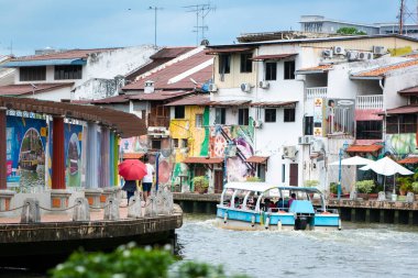 MELAKA, MALAYSIA - June 11, 2022: River cruise along the Melaka river surrounded by colorful houses and buildings. Melaka city is a designated UNESCO world heritage site.