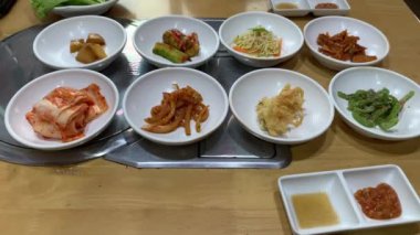 Traditional Korean food with small side dishes called banchan in a restaurant.  Top view shot.