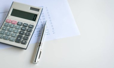 Calculator and pen on top of spreadsheet, copy space. Financial accounting concept.