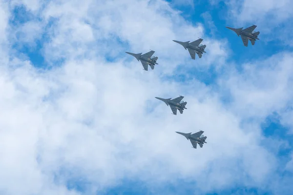 Military aircraft in formation flying in the sky.
