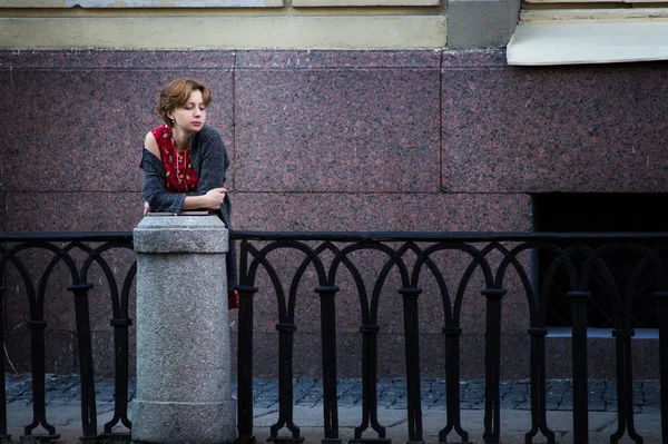 Chica con el pelo rojo rizado esperando en el puente — Foto de Stock